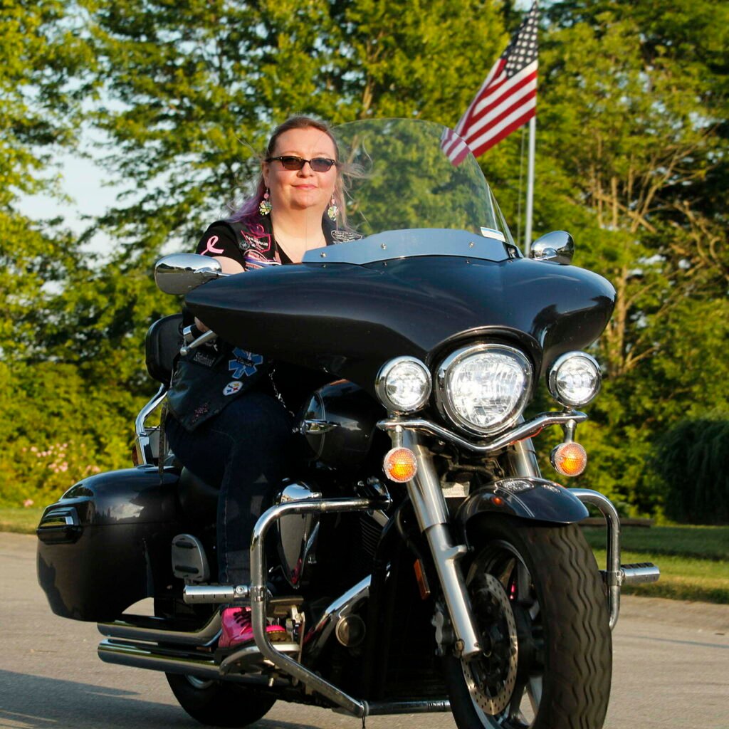Woman riding her Harley Davidson in the sunset