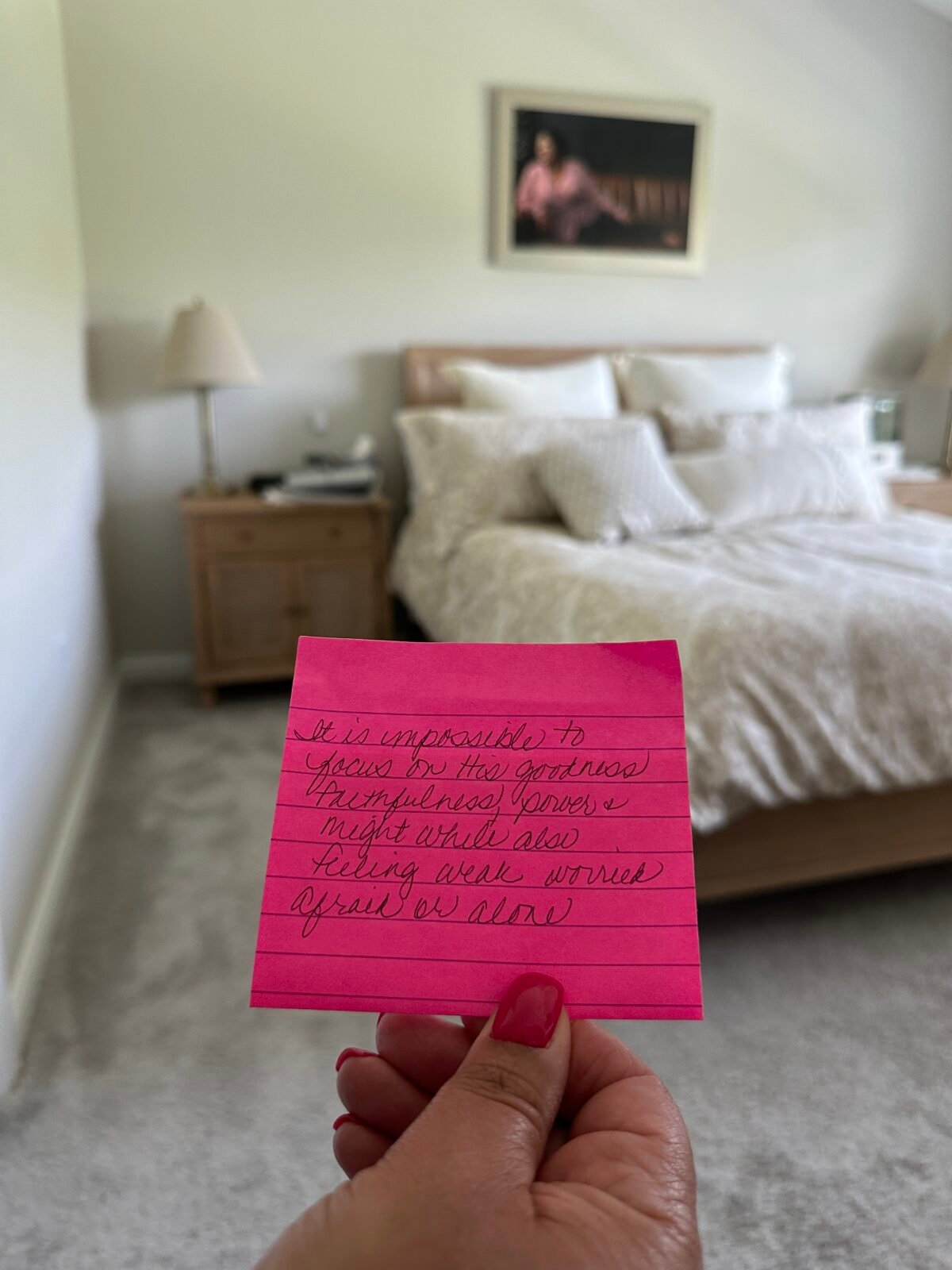 note in front of bed with picture of Regina on the wall. The pink note says, "It is impossible to focus on the goodness, faithfulness, power and might while also feeling weak, worried, afraid  or alone.