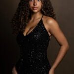 Gallery image of Black Model with curly Hair and a black sparkling Dress