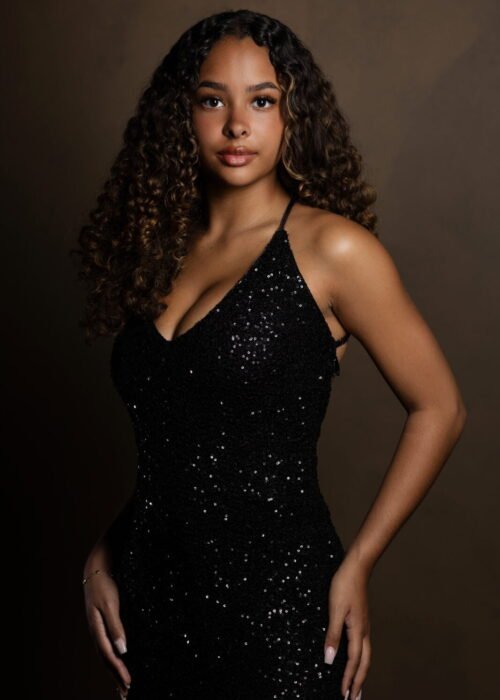 Black Model with curly Hair and a black sparkling Dress