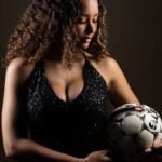 Gallery image of Model holding soccer ball in sparkly dress