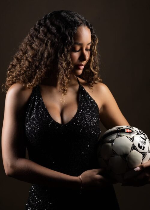 Model holding soccer ball in sparkly dress