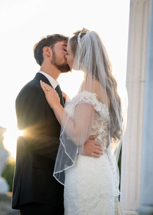 Beautiful image of wedding couple with romatic kiss and sunlit background